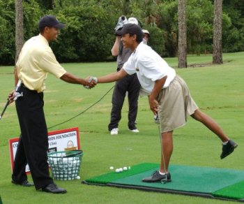 Tiger Woods shakes hands with junior golfer Charles Pantango, 17, of Ft. Worth, Texas, after giving him a few tips on his game June 18 at Disney's Palm course. Copyright © 2002, THE WALT DISNEY COMPANY.