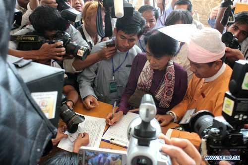 Aung San Suu Kyi (C), leader of Myanmar's National League for Democracy (NLD) and parliament representative-elect signs to attend Myanmar's parliament in NayPyiTaw, May 2, 2012.