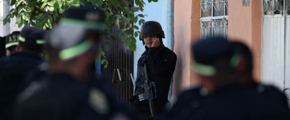 Police officers stand guard near a crime scene in Neza, on the outskirts of Mexico City, on January 16, 2011. (Reuters/Jorge Dan)