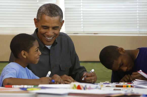 Obama smiles as he works on a literacy project with children during a day of service at the Boys & Girls Club in Washington