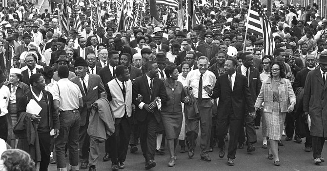 Dr. Martin Luther King Jr. marching with other civil rights activists across the Edmund Pettus Bridge in Selma, Alabama. Photo: The Dallas Examiner.