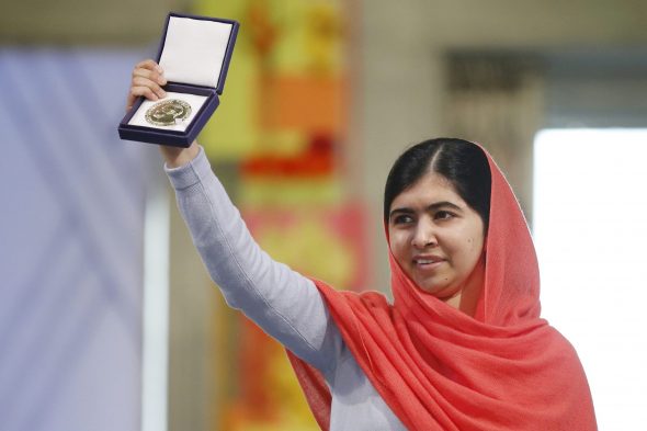 Malala posing and celebrating being awarded the Nobel Peace Prize in 2014.
